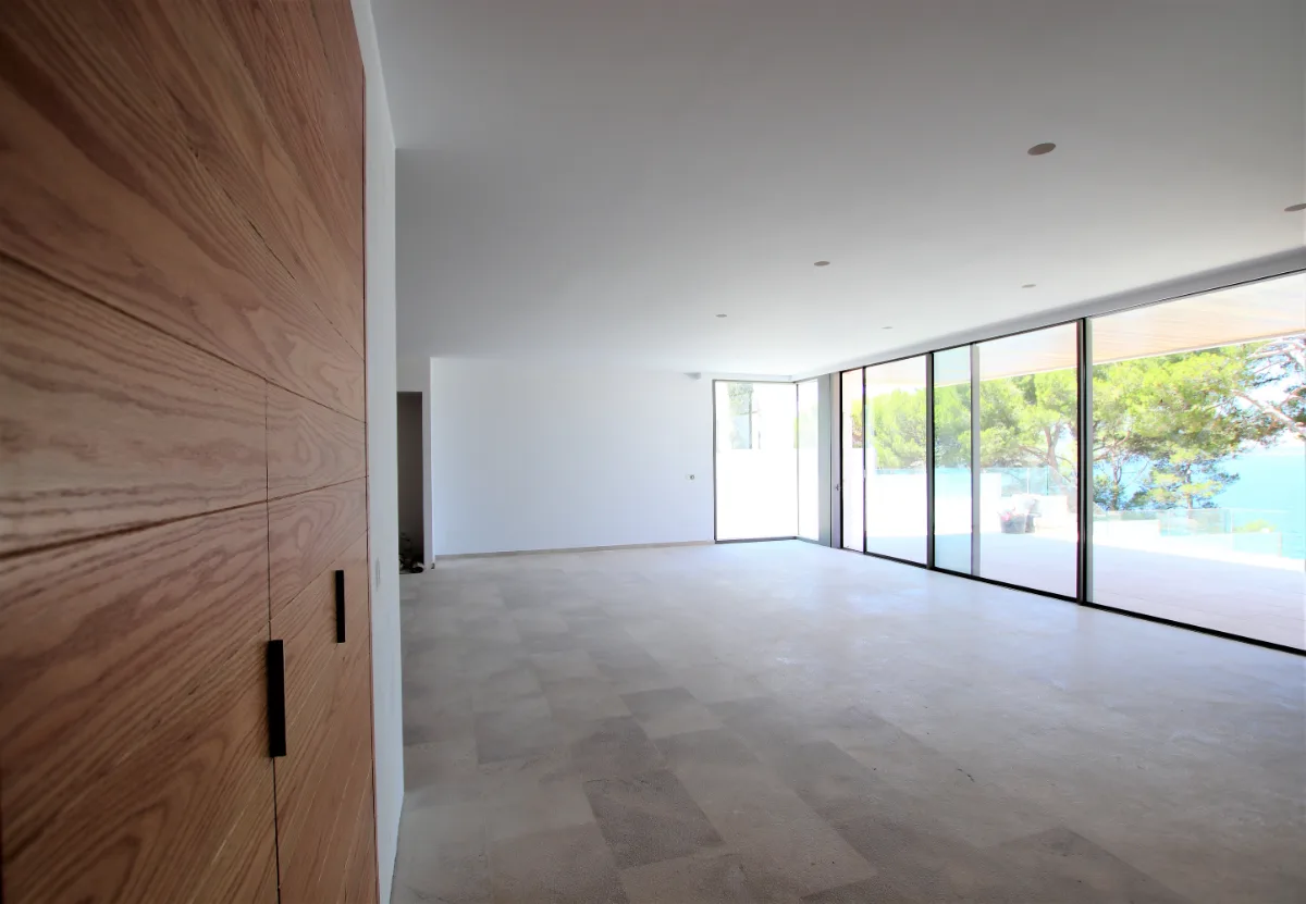 Offener Wohnraum mit raumhoher Holzwand und Glasfront zur Terrasse